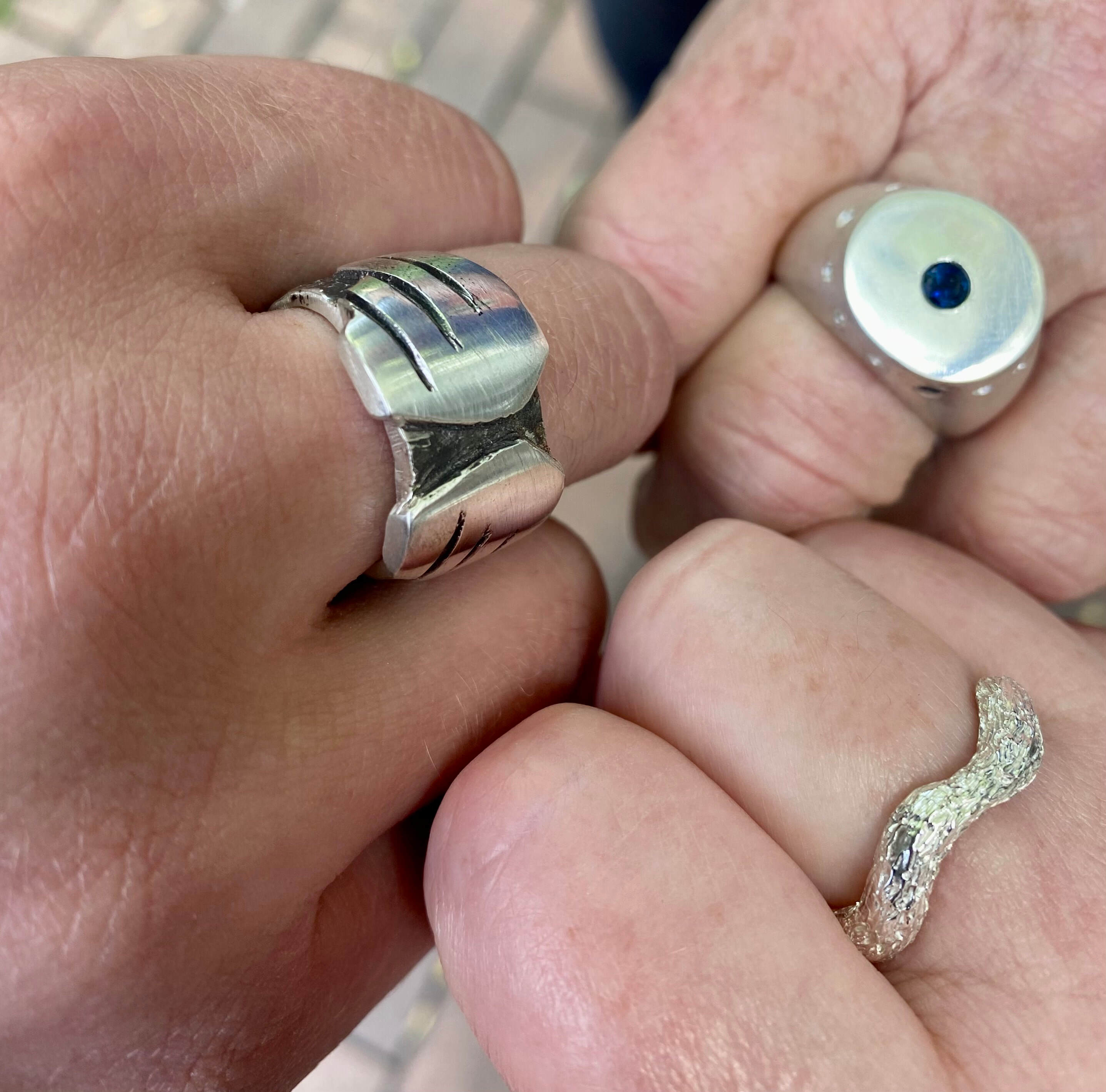 Hands with silver rings which are made in the wax carving class