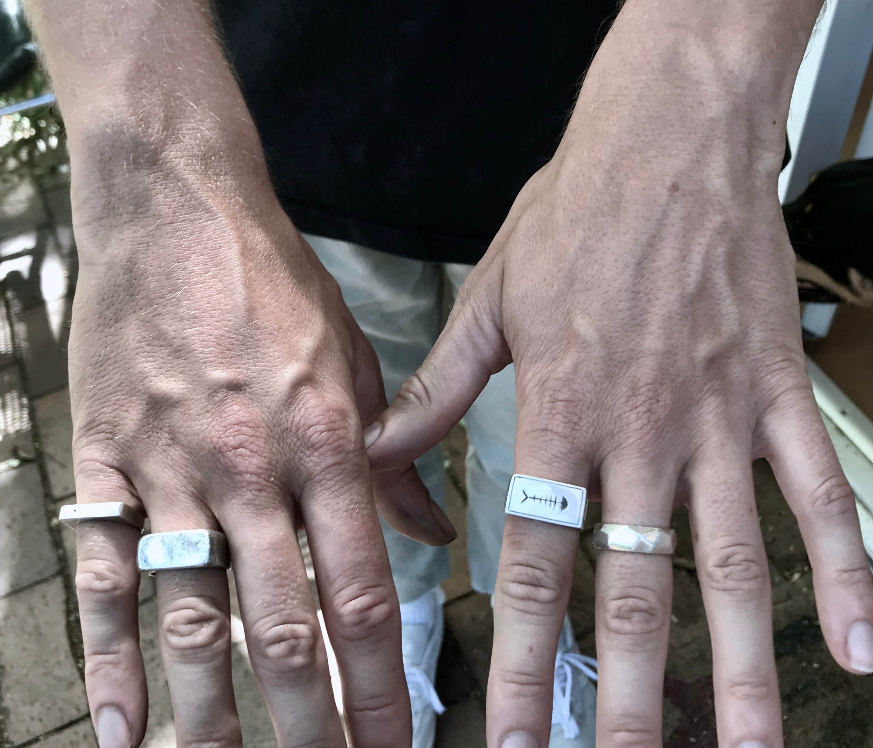 Hand with silver rings featuring handmade rings which are created in the wax carving class
